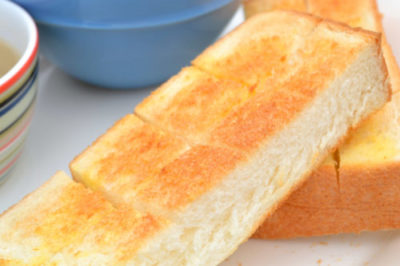 背景に青い食器が映るトースターで焼いた食パン
